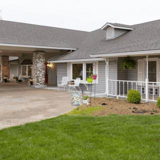 A view of a suburban house with a driveway and well-maintained lawn.