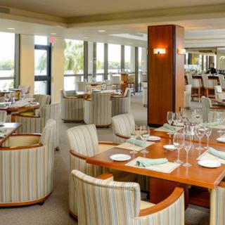 A spacious and elegantly designed restaurant with neatly arranged tables, ready for diners.