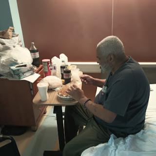 A patient enjoying a meal at a hospital bedside.
