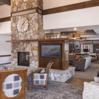 A spacious and modern lobby featuring a stone fireplace, comfortable seating, and stylish decor.