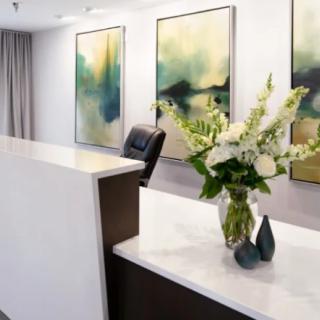 A modern reception area with abstract artwork and a floral arrangement.