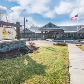 The welcoming entrance of a community center featuring a prominent sign and landscaped grounds.