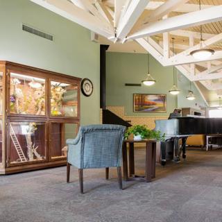 A modern waiting area with comfortable seating and a glass display cabinet.