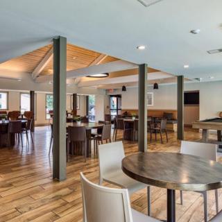 A spacious restaurant interior with wooden flooring and multiple seating arrangements.