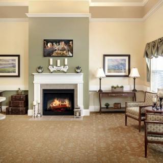 A cozy living room featuring a fireplace, elegant furniture, and tasteful artwork.