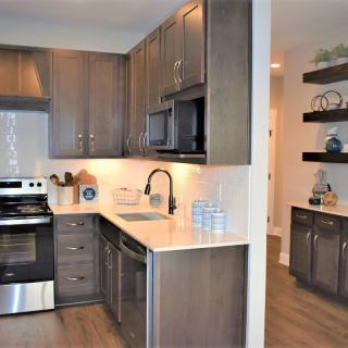 A modern kitchen interior with dark wood cabinets and stainless steel appliances.