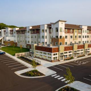 A modern residential apartment complex featuring stylish architecture and ample parking.