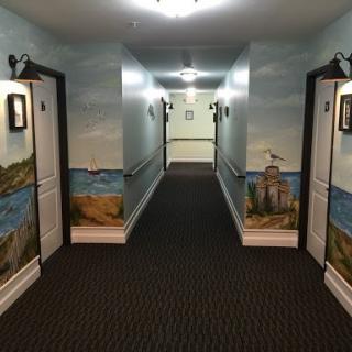 A well-decorated hotel hallway featuring scenic murals and soft lighting.