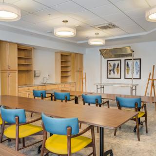 A modern conference room with colorful chairs, wooden tables, and contemporary lighting.