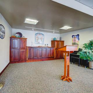 A well-furnished office space featuring a podium, wooden cabinets, and decorative plants.