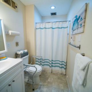 A clean and well-organized bathroom with a shower curtain, toilet, and sink.