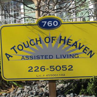 A sign for 'A Touch of Heaven Assisted Living' with contact details.