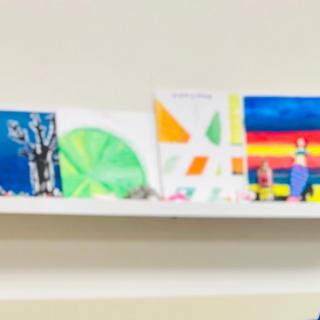A series of colorful artworks displayed on a shelf.