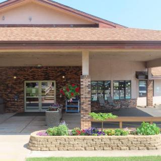 A welcoming entrance to a well-maintained building with lush landscaping.