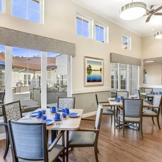 A bright and spacious dining room with neatly arranged tables and chairs.