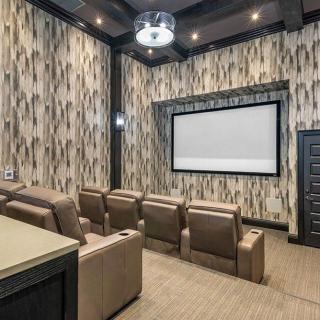 A luxurious home theater with comfortable seating and a large projector screen.