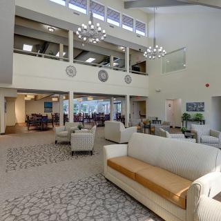 A spacious and modern lobby with comfortable seating and elegant chandeliers.