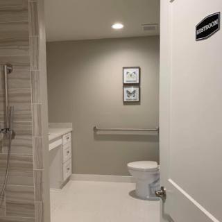 A clean and modern bathroom featuring a toilet, sink, and shower.