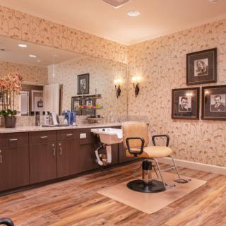 A cozy and stylish hair salon interior with a hairdressing chair, mirror, and decorative elements.