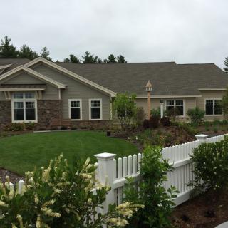 A suburban house with a well-maintained garden and white picket fence.