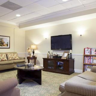A cozy living room with comfortable seating, a television, and warm lighting.