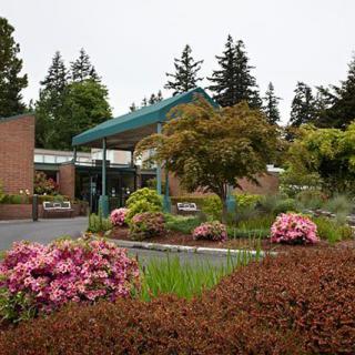 A beautifully landscaped garden with vibrant flowers and a building in the background.