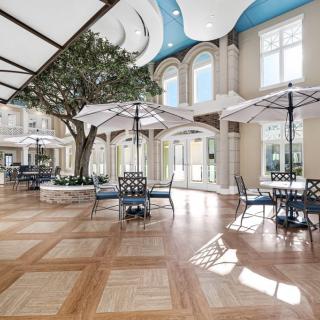 A spacious indoor seating area with umbrellas and natural light.