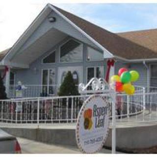 A building with a sloped roof, adorned with colorful balloons and a sign near the entrance.