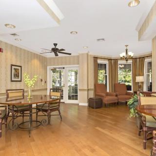 A spacious living room with elegant decor, featuring a seating area and wood flooring.