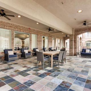 A spacious outdoor patio with comfortable seating and a tiled floor.