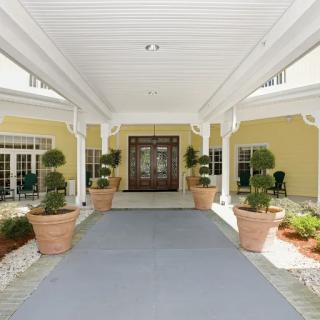A covered entrance with large planters leading to a building's doorway.