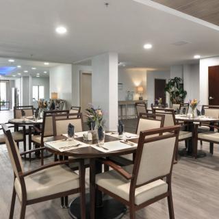 A modern dining area with neatly arranged tables and chairs, featuring contemporary decor.