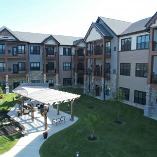 A modern apartment complex with well-maintained landscaping and outdoor seating areas.