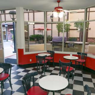 A retro-style cafe with checkered flooring and red and black decor.