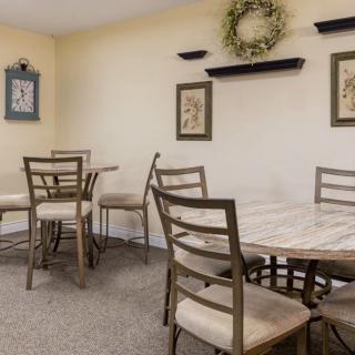 A cozy dining area with wooden tables and chairs, adorned with wall decorations.