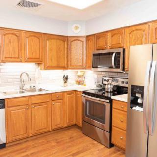 A modern kitchen with wooden cabinets and stainless steel appliances.
