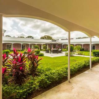 A view of a well-maintained courtyard garden surrounded by a building with arched walkways.