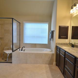 A modern bathroom featuring a bathtub, separate shower, and dual sink vanity.