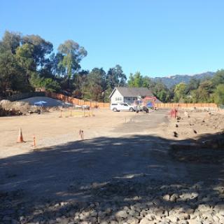 A construction site in a rural area, featuring an excavated landscape and ongoing work.