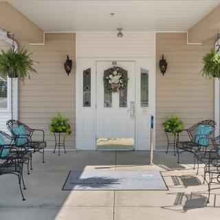 A welcoming entrance with outdoor seating and decorative plants.