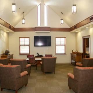A modern lounge area with comfortable chairs and a large television.
