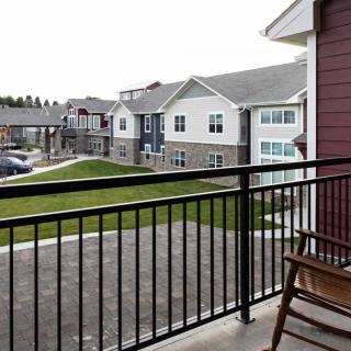 A view from a balcony overlooking a residential area with modern apartment buildings.