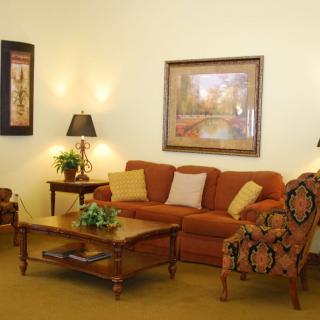 A cozy living room with warm-toned furniture and decorative artwork.