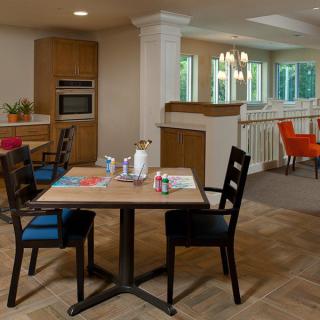 A modern kitchen and dining area with a wooden table, chairs, and open layout.