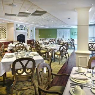 An elegant restaurant dining room with neatly arranged tables and chairs.