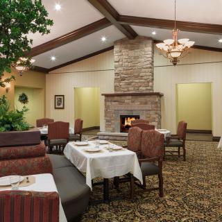 A cozy restaurant interior with a fireplace and neatly set tables.
