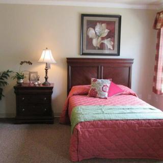 A cozy bedroom with a bed, nightstand, and decorative elements.