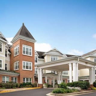 Exterior of a senior living facility with a welcoming entrance and classic architecture.