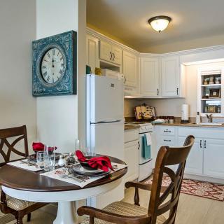 Cozy kitchen and dining space with white cabinets and a round table set for two.