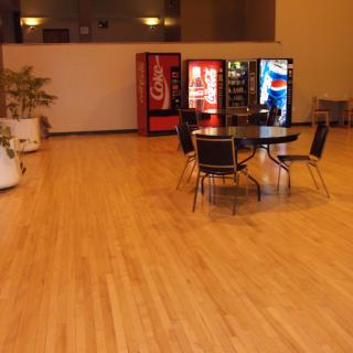A waiting area with vending machines, chairs, and a table.